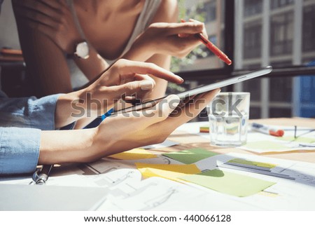 Closeup photo Girl Touching Screen Digital Tablet Hand.Project Producers Researching Process.Young Business Crew Working New Startup modern Studio.Analyze market stock.Blurred,film effect.Horizontal