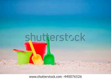 Kid's beach toys on white sand. Buckets and blades for kids on the white sandy beach after children's games