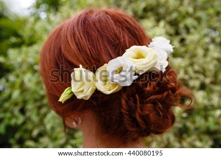 Young woman bride with beautiful hairstyle and stylish hair accessory, rear view. park background