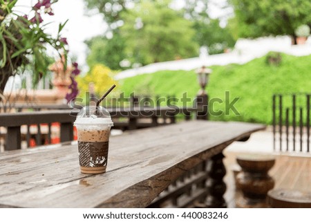 Ice coffee in plastic glass on the table.
