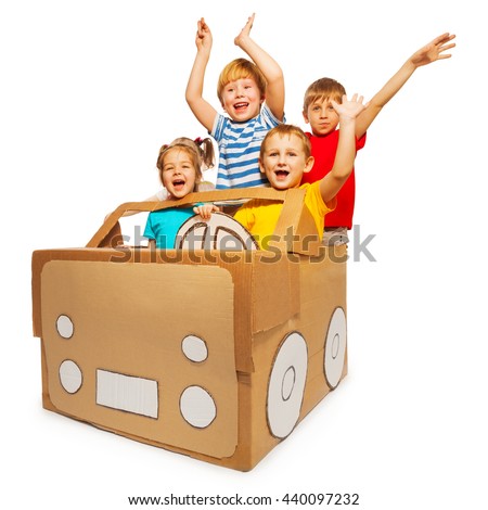 Happy kids waving hands sitting in cardboard car
