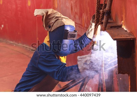Male  worker wearing protective clothing and repair welding industrial construction oil and gas or  storage tank inside confined spaces.