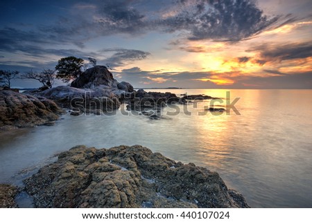 A Long Exposure Picture Of Beautiful Scenery Sunset With Big Stone As Background
