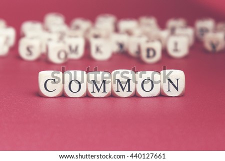 Common word written on wood cube with red background