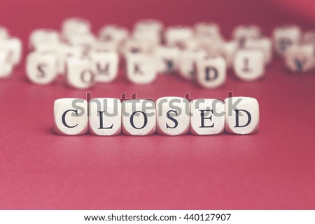 Closed word written on wood cube with red background