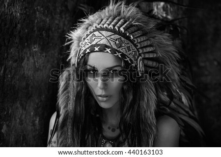 Attractive woman in chieftait outdoors. Native american style