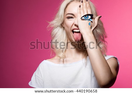 funny hipster girl with a tearful eye painted on your arm posing for the camera
