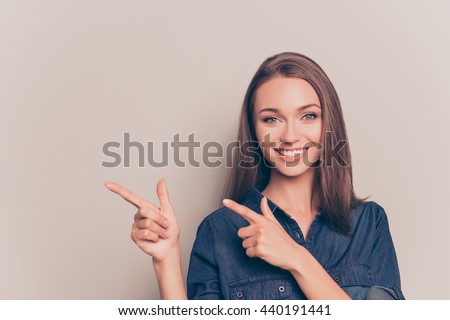 Pretty cheerful woman gesturing with fingers and showing away Royalty-Free Stock Photo #440191441