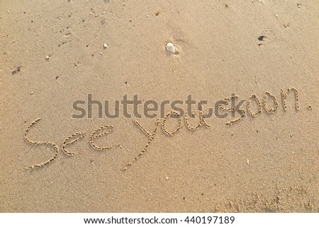 written words "See you soon" on sand of beach Royalty-Free Stock Photo #440197189