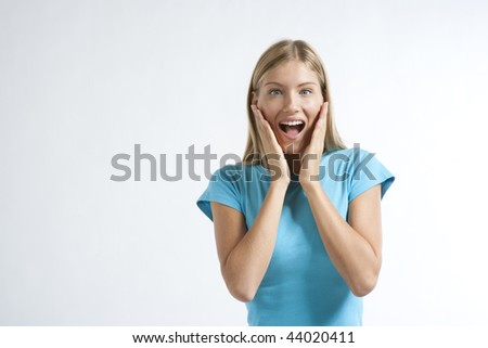 Close-up of a young woman looking excited against white background