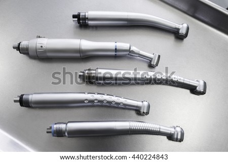Set of dental turbine handpieces without burs flat lay. Top view on set of dental turbine handpieces on metal medical tray. Royalty-Free Stock Photo #440224843