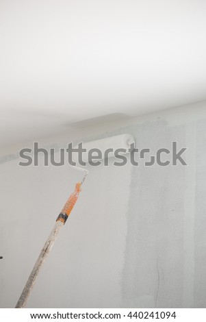 painting a wall with paint roller