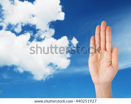 Woman hand and make stop hand sign symbol on blue sky concept.