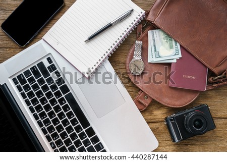 Business concept for office workplace with laptop phone money passport and list note book activity list on table.Business successful and work space on desk from above concept with vintage color effect