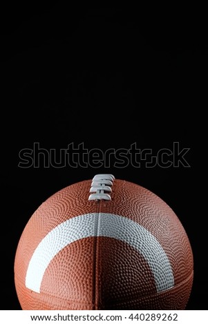 Isolated American football ball on high contrast black background