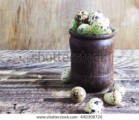 Quail eggs in a wooden glass on a wooden background, rural style, selective focus