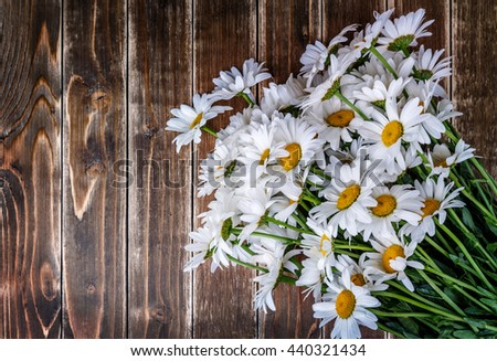 chamomile flowers on wooden table background board texture