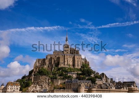 Mont Saint Michel in Normandy, a popular UNESCO world heritage site in France, with a blue and cloudy sky