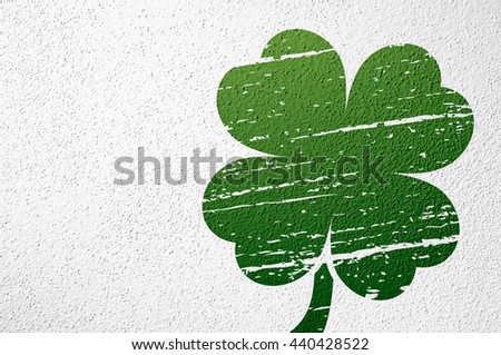 White wall plaster texture background with green four leaf clover