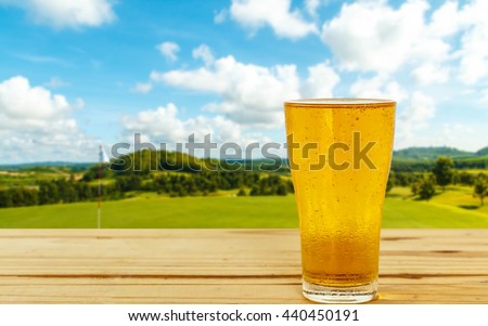 Glass of beer on the background blur of golf.