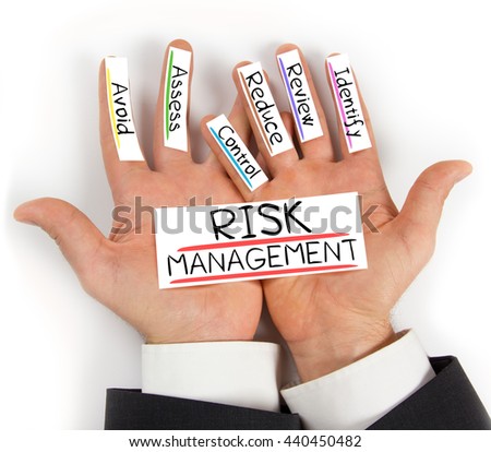 Photo of hands holding paper cards with RISK MANAGEMENT concept words