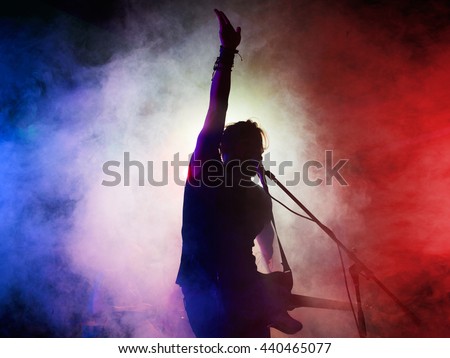 Silhouette of guitar player on stage. Dark background, smoke, spotlights Royalty-Free Stock Photo #440465077