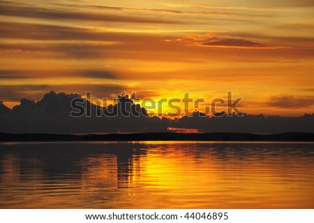 The final stage of a cloudy sunset above the huge lake in Karelia region. The picture is colorful and relaxing.