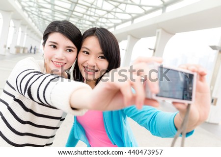 Women taking selfie by digital camera