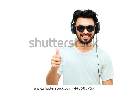 Asian handsome man with a mustache, smiling and laughing and using smart phone to listen music with headphones ,Blurry and soft focus
