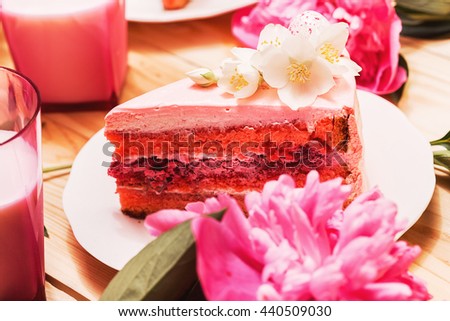 Food, food styling, cooking. Pink slice of cake with beautiful flowers on wooden table