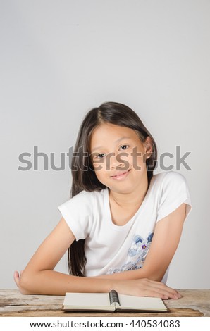 Student studying at the desk on white background. Young Asian girl studying.