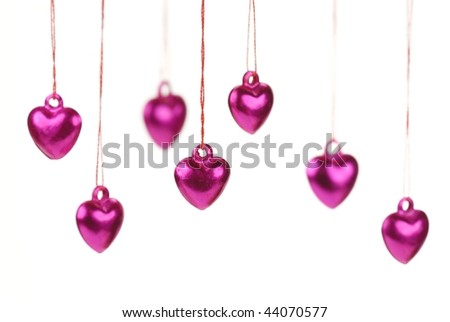 Shiny heart trinkets hanging on the white