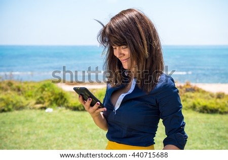 Beautiful woman posing in a park and talking to mobile