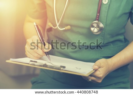  female doctor,surgeon,nurse,pharmacy with stethoscope on hospital holding clipboard,writing a prescription,Medical Exam,Healthcare and medical concept,test results,vintage color,selective focus Royalty-Free Stock Photo #440808748