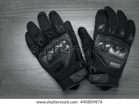 Motorcycle gloves on wooden background,with copy space.monochrome.
