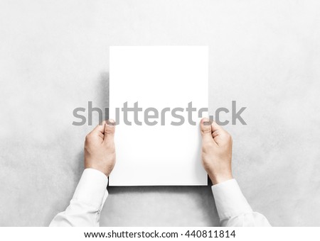 Hand holding white blank paper sheet mockup, isolated. Arm in shirt hold clear brochure template mock up. Leaflet document surface design. Simple pure print display show. Reading contract agreement. Royalty-Free Stock Photo #440811814