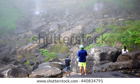 Group Travel Standing on the rocks and gaze at the waterfall, waterfall with Plant in the surrounding, bolaven plateau Laos