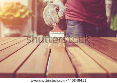 Close up paintbrush in hand and painting on the wooden table. Retro and vintage style Royalty-Free Stock Photo #440848411