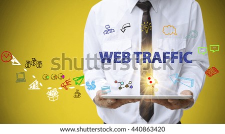 businessman holding a tablet computer with WEB TRAFFIC text ,business analysis and strategy as concept