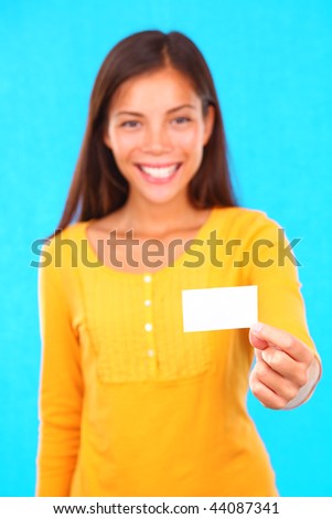 Exotic young woman on colorful background holding a blank business card with copy space.
