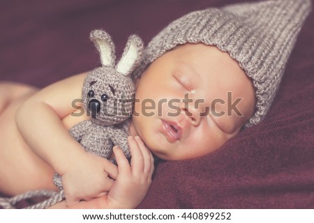 Newborn baby peacefully sleeping. picture of a newborn baby curled up sleeping on a blanket. Newborn baby is sleeping