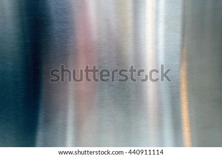Convex polished shiny steel metal surface with multicolored reflections and glare