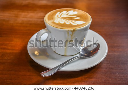 A Cup of hot latte art coffee on wooden table Royalty-Free Stock Photo #440948236