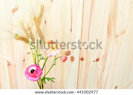 Colorful beautiful flowers and wheat ears on a wooden background. Seasons. Summertime. Vacation. Rustic style.Toned colors image