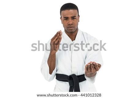 Fighter performing karate stance on white background