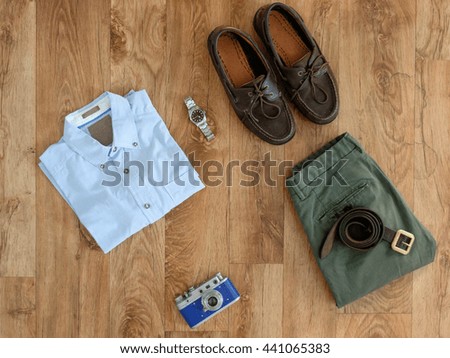 Top view of stylish clothes isolated on wooden background
