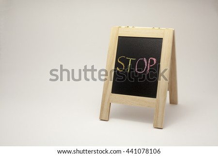 wording stop sign concept with small blackboard on white gradient background. colorful chalk