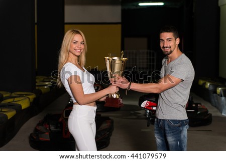Young Woman Gives Man A Cup Speed Karting Race
