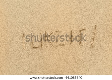 written words "I LIKE IT!" on sand of beach