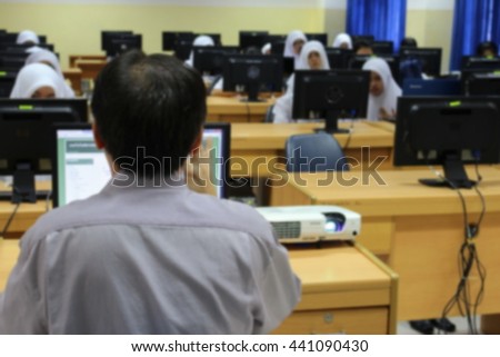 student with teacher  learning  business technology  desktop computer room in  teaching lab  education Abstract Blur blurred 